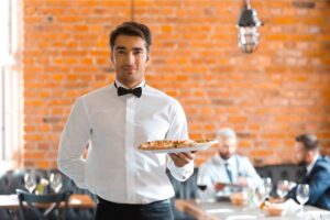 Un cameriere pronto a servire ai tavoli