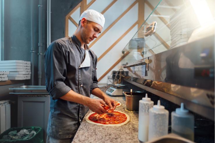 Un pizzaiolo intento a preparare una pizza